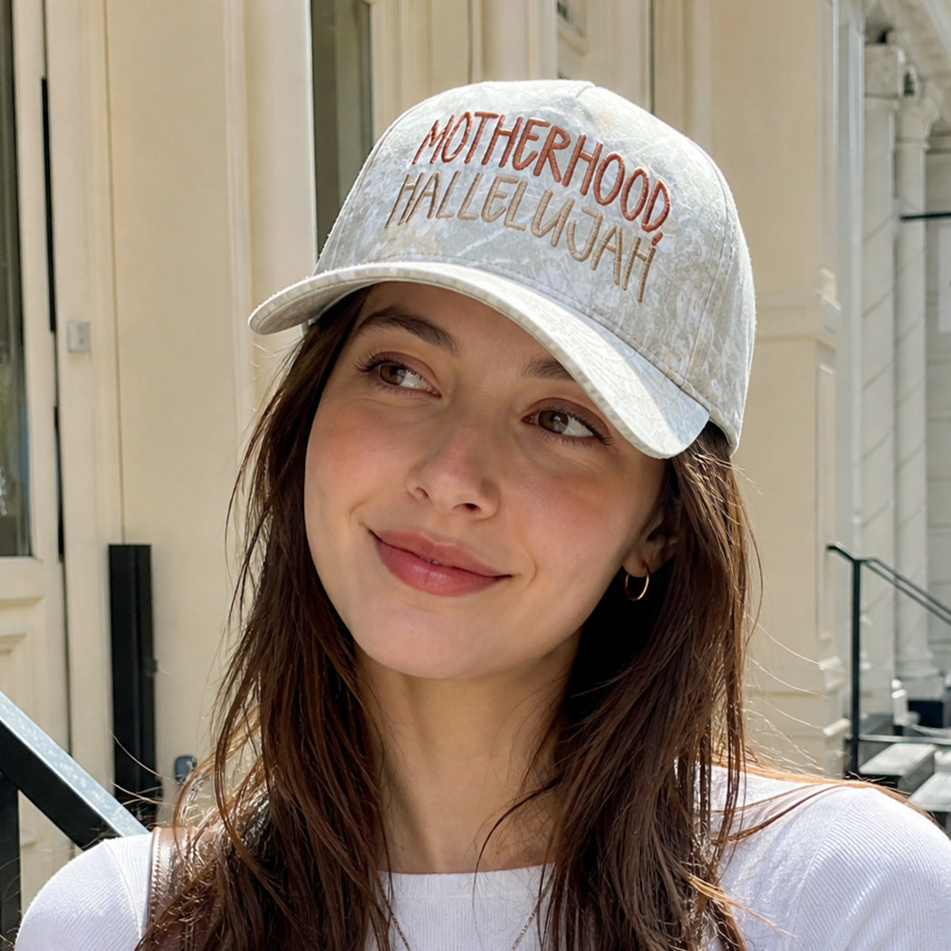 Motherhood Hallelujah embroidered camo trucker hat, front view