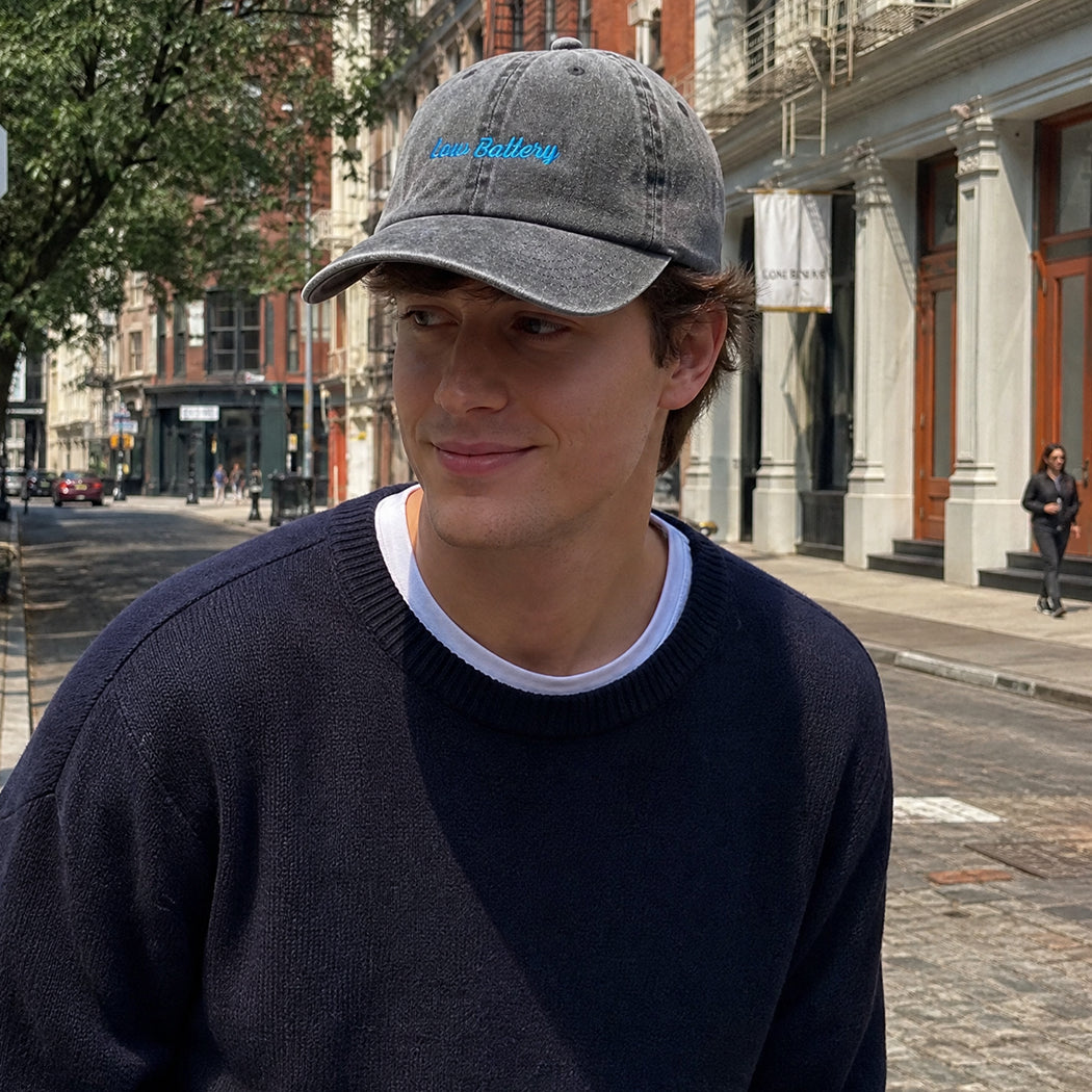 Model wearing Low Battery embroidered baseball cap