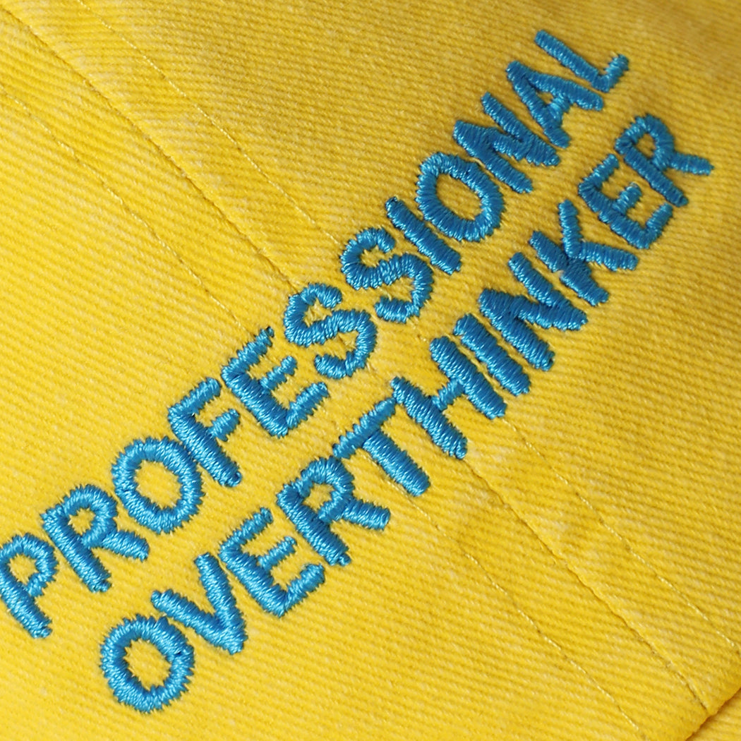 Professional Overthinker washed baseball cap in yellow, side view