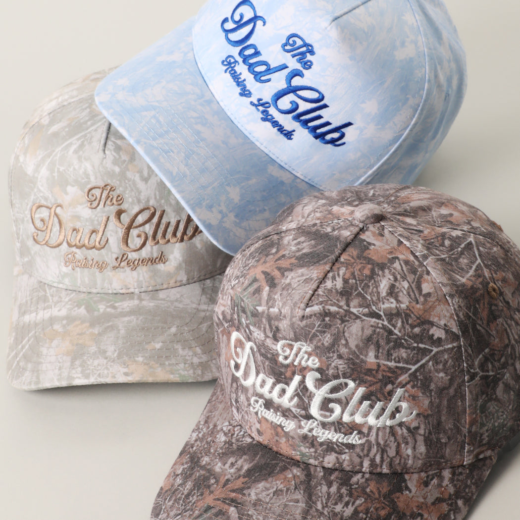 The Dad Club Raising Legends embroidered camo trucker hat, front view