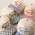 Hotter Than a Hoochie Coochie checkered brim trucker hat shown in all color options