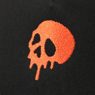 Skull Drip mesh trucker hat in black and orange, side view