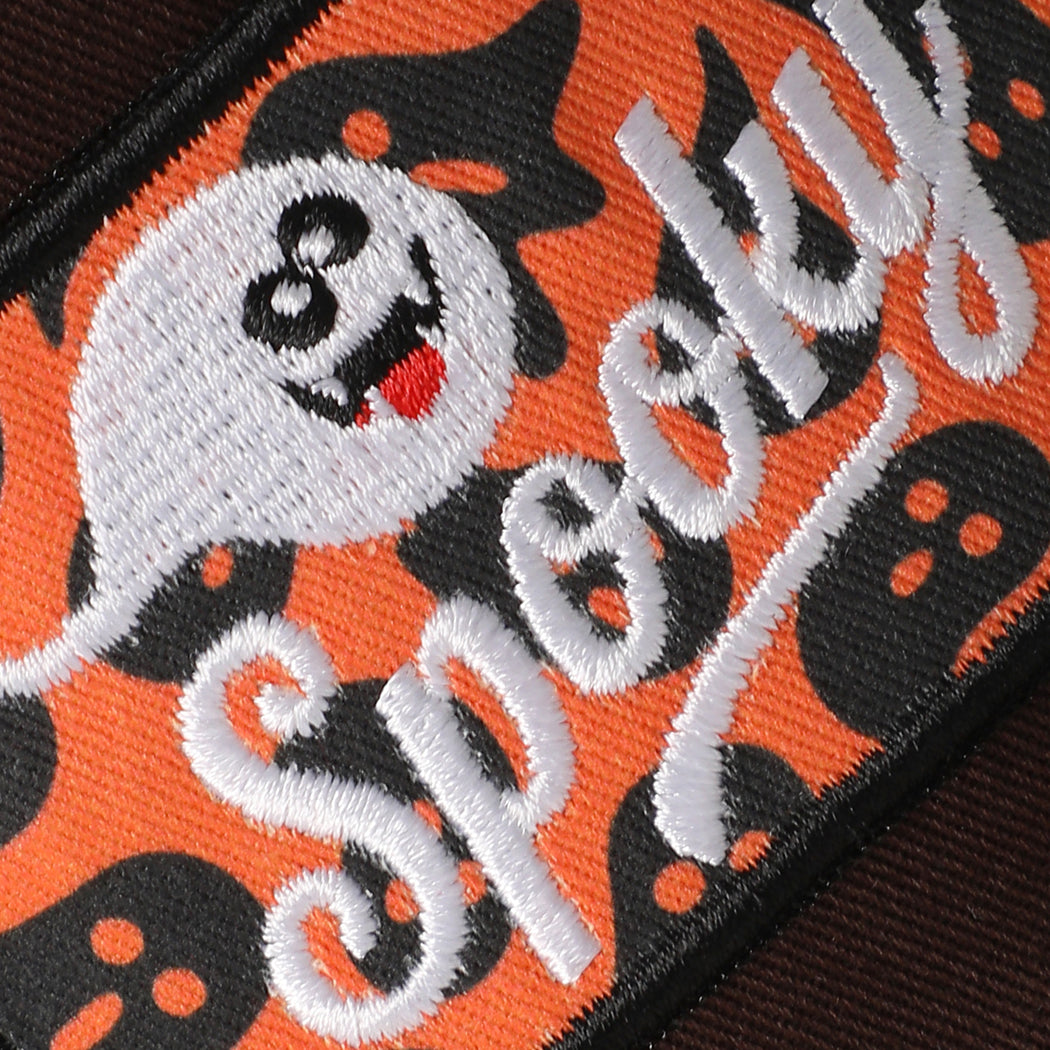 Spooky ghost patch cow-print brim trucker hat in brown, angled view